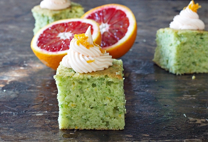 A slice of cake next to a cut orange.