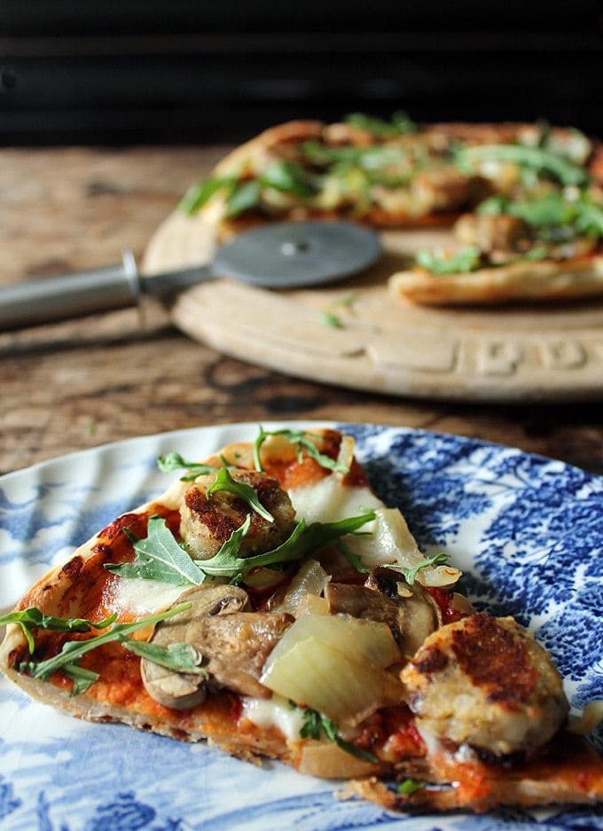 Vegetarian Sausage Skillet Pizza on a vintage plate with the pizza in the background