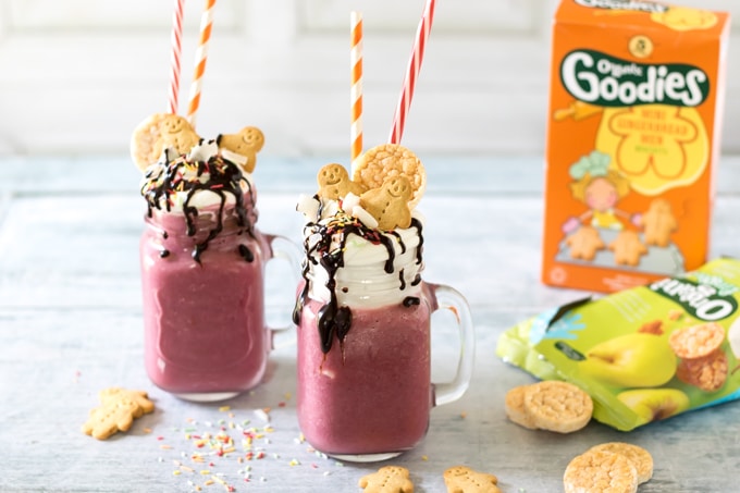 Two glasses of vegan Vanilla Beet Freakshakes - bright purple tasty milkshakes topped with coconut cream, chocolate sauce, sprinkles and cookies.