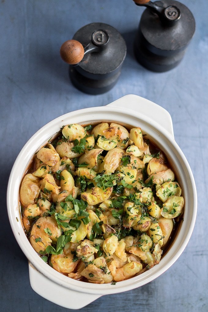A casserole dish of cooked vegan shepherd's pie with crushed new potatoes instead of mashed potato.