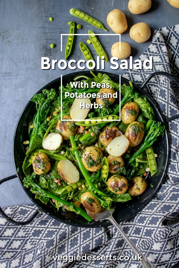 A bowl of broccoli salad with potatoes, herbs and peas. A hearty vegan gluten free salad - in a bowl on a navy background