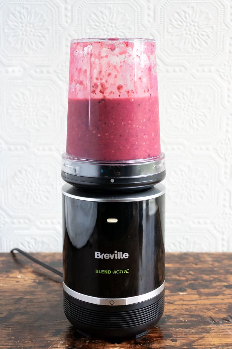 Breville Blend Active Pro Food Prep Blender Set with acai smoothie being blended in it.