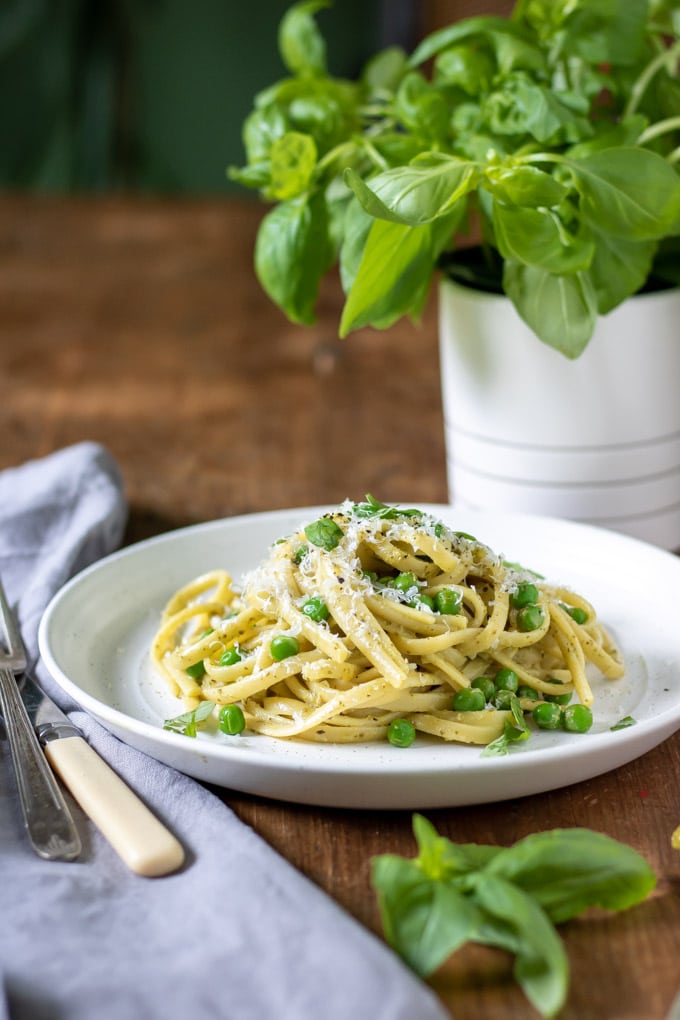 Table set with a plate of pasta, cutlery and napkin.
