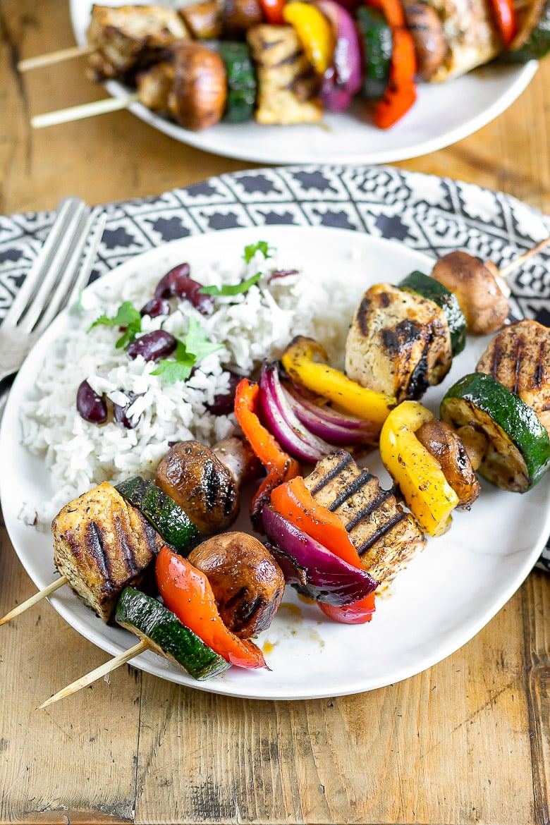 A plate of rice and peas with grilled Jerk Tofu and vegetables.