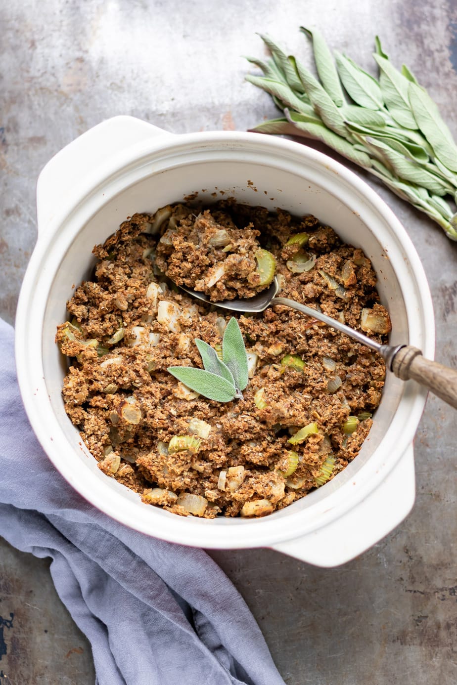 Casserole dish of Vegan Stuffing with sage leaves on top.