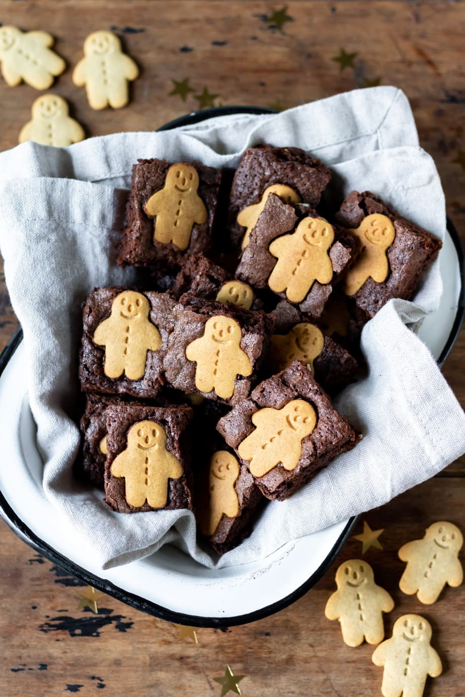 Looking down at enamel dish full of brownies topped with mini gingerbread men.