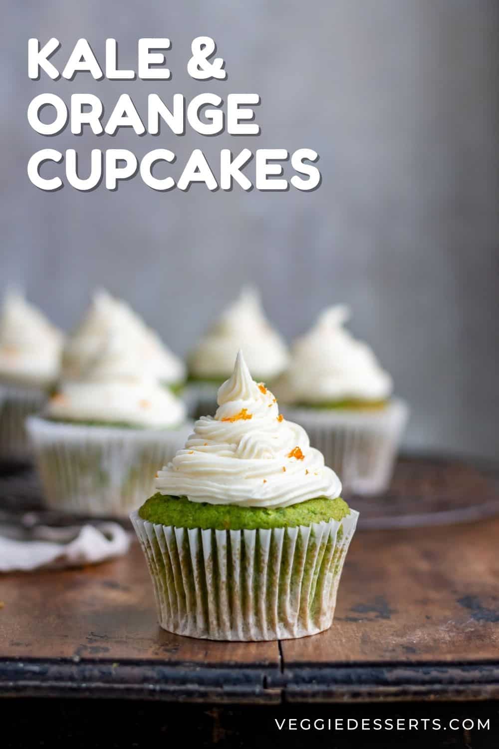 Cupcakes on a wooden table, with text: Kale and Orange Cupcakes.