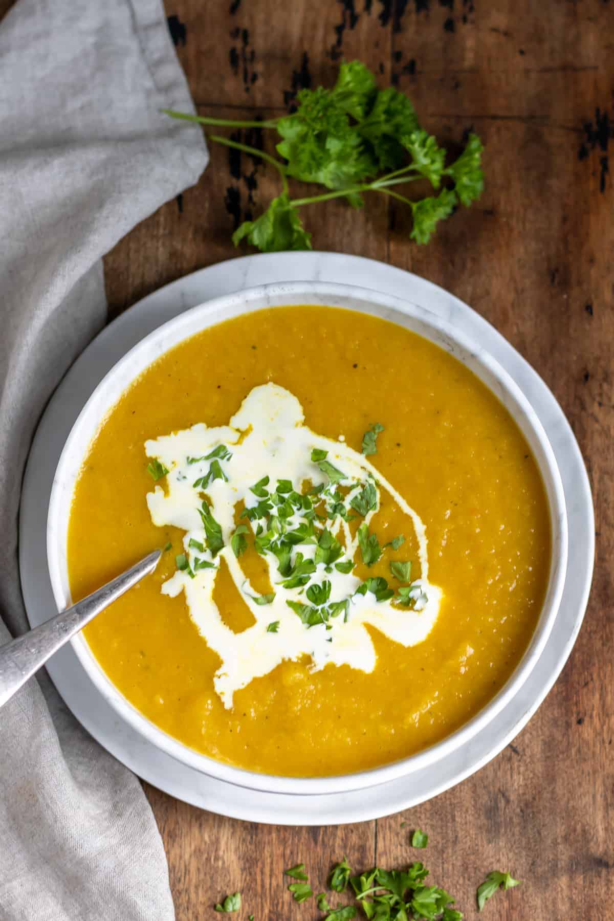 Wooden table with a bowl of soup.