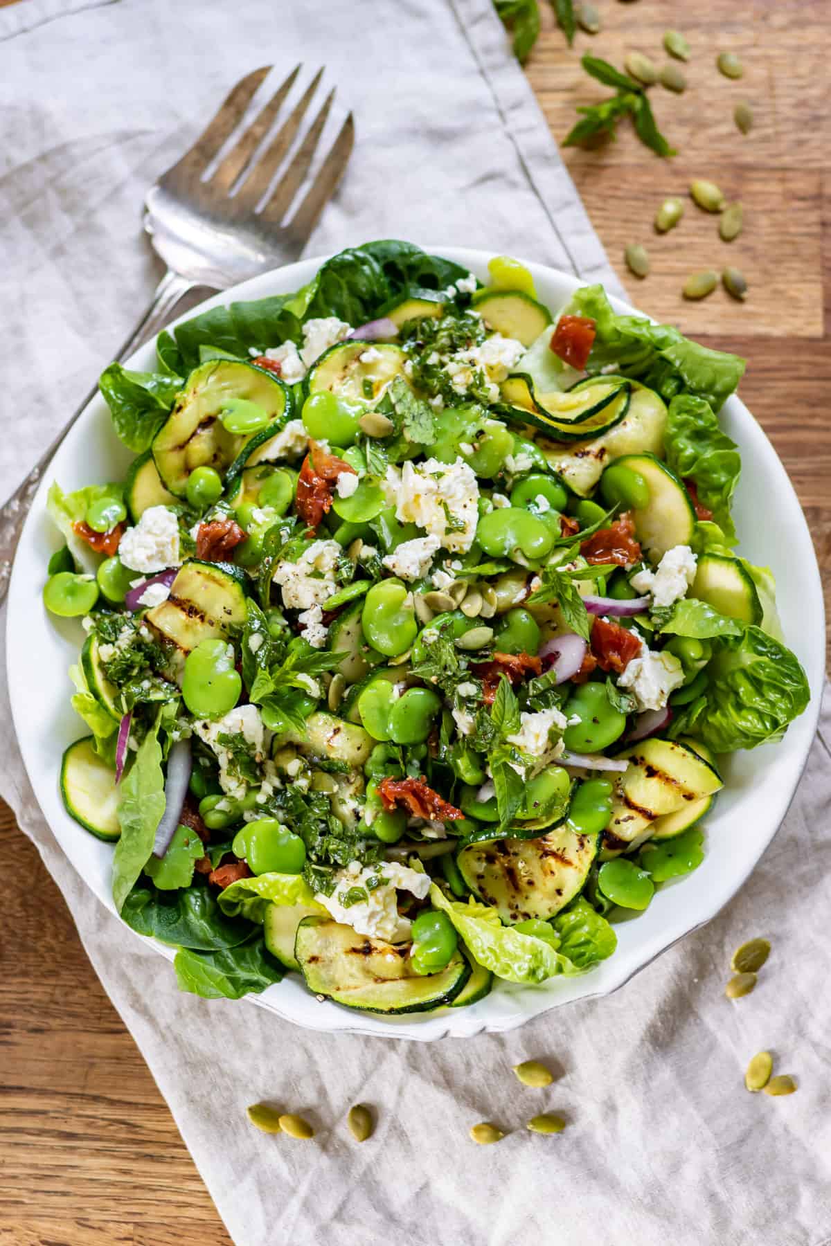 Bowl of broad bean salad on a tabe.