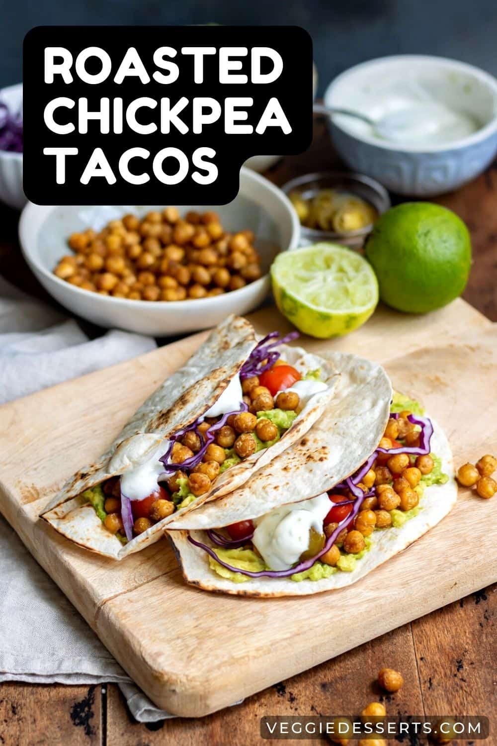 Chickpea tacos on a wooden board in front of ingredients.