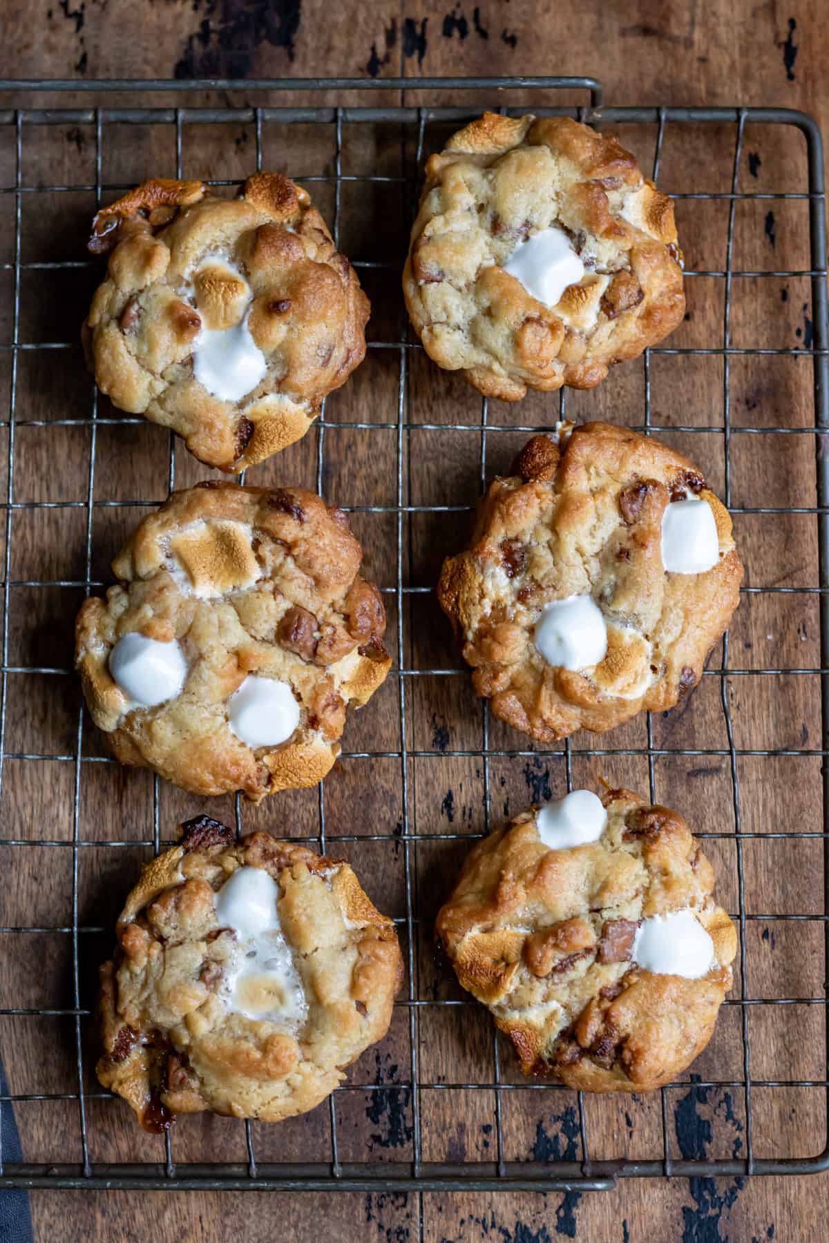 Rows of marshmallow chocolate chip cookies on a wire rack.