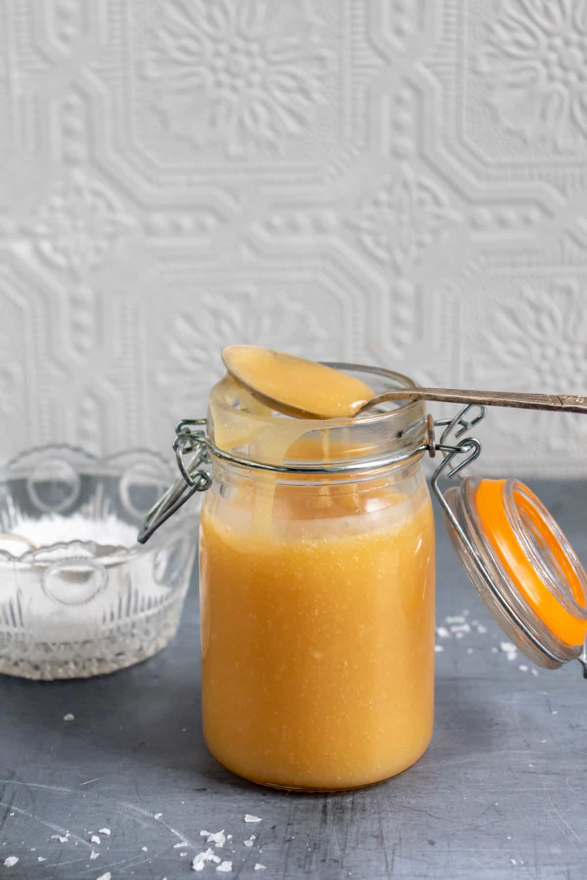Spoonful resting on a jar of salted caramel sauce.