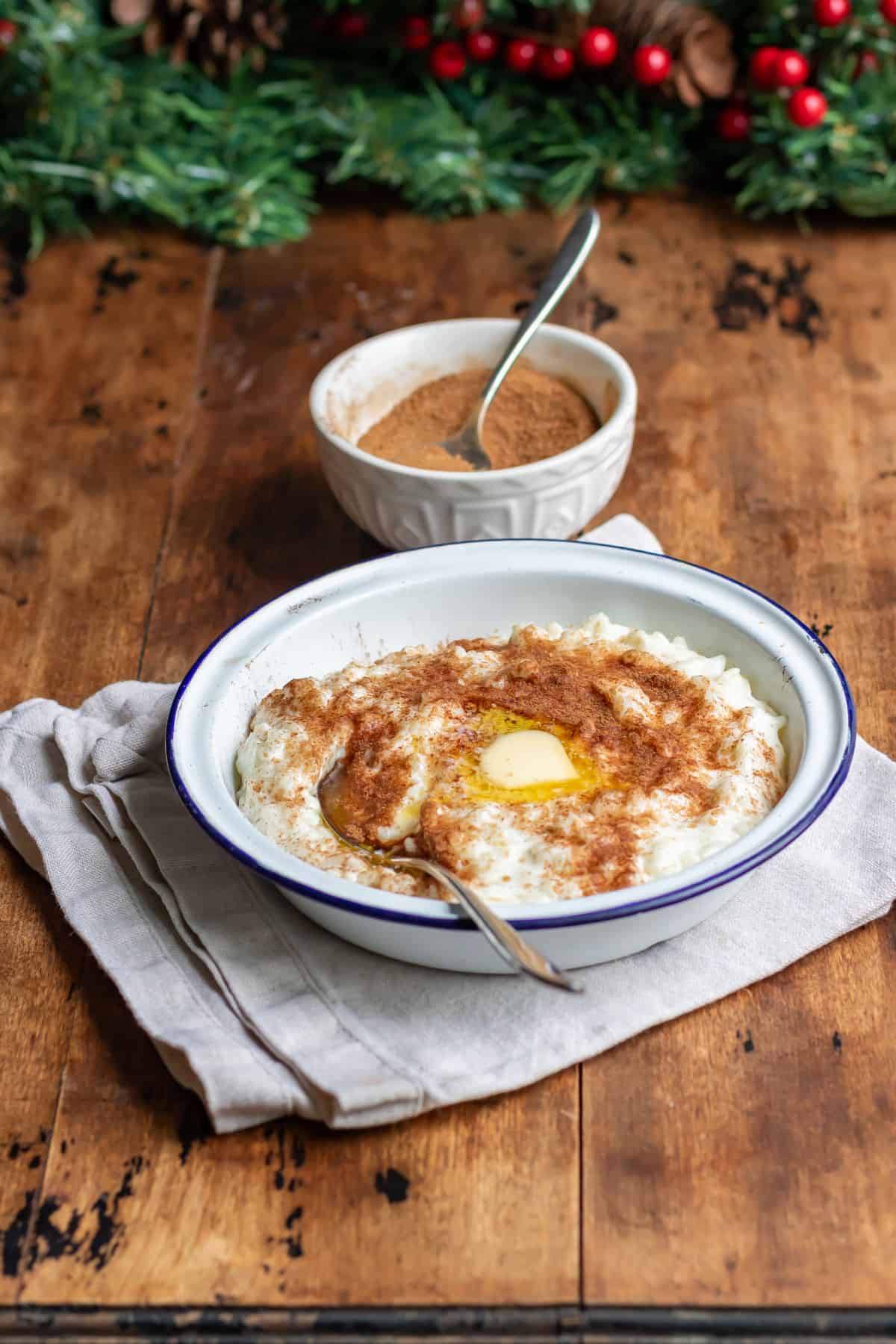 Wooden table, Christmas garland, and a bowl of risengrod / risgrynsgr