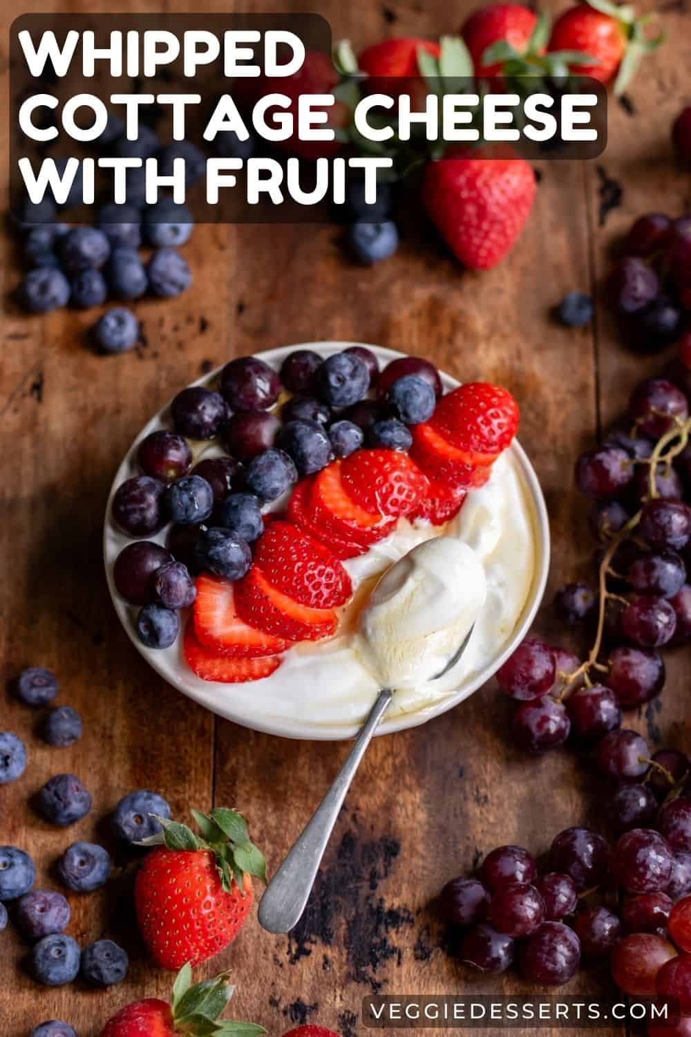 Dish of cottage cheese surrounded by fruit, with text: Whipped Cottage Cheese with Fruit.