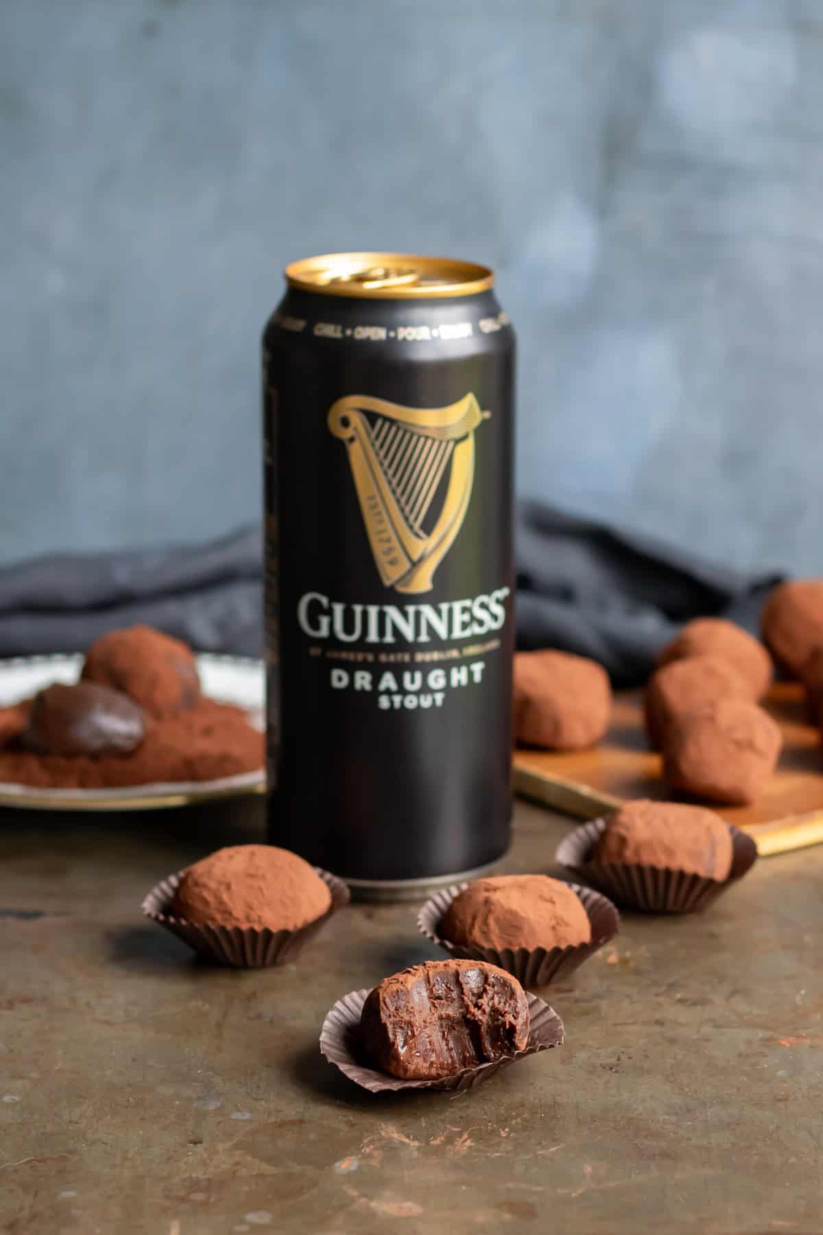 A table with a can of Guinness, as well as Guinness truffles with one with a bite out.