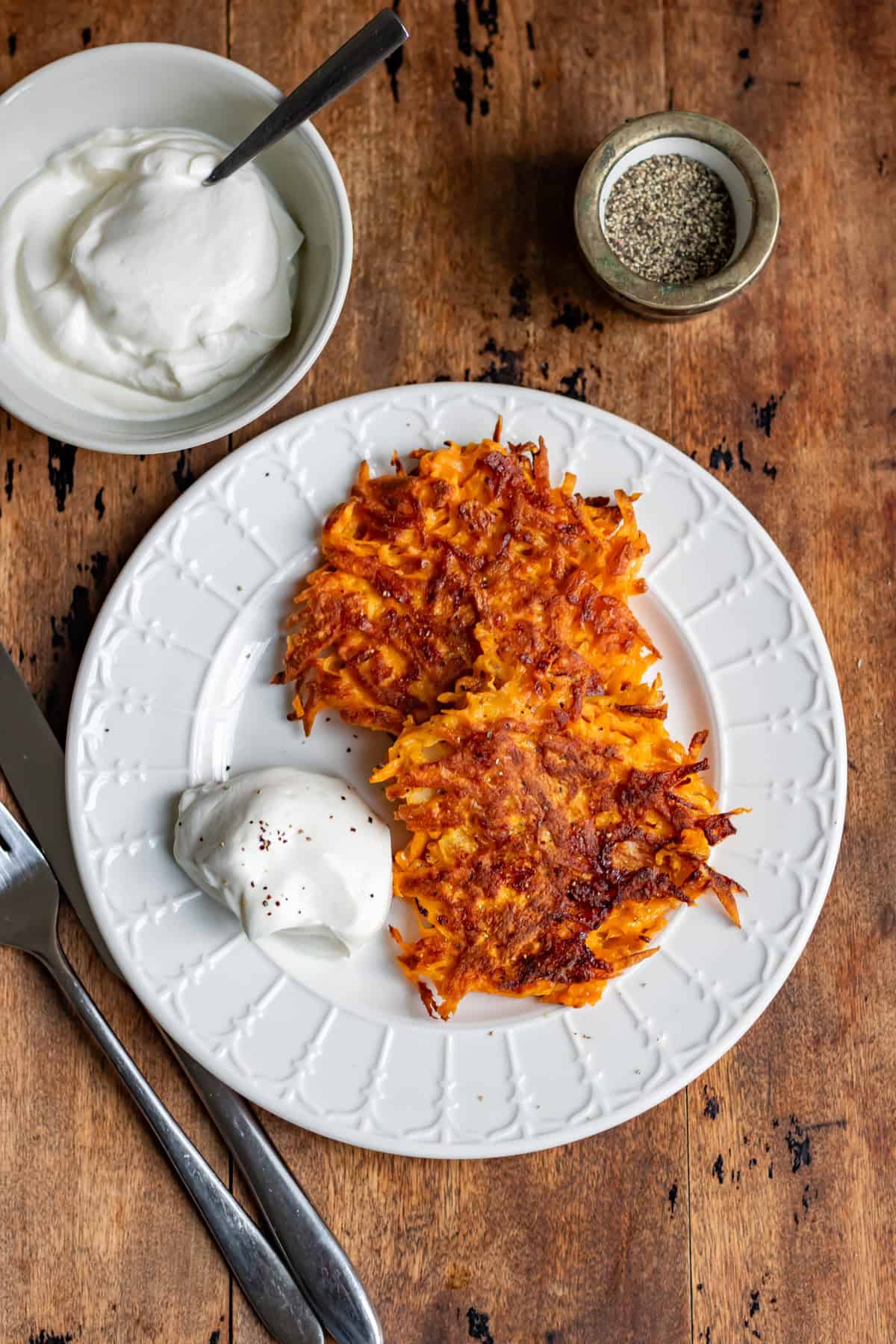 Sweet potato fritters on a plate on a wooden table.