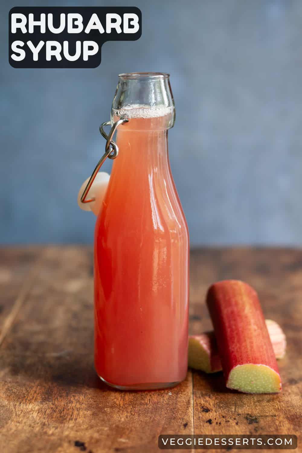 Table with a bottle of simple syrup with text: Rhubarb Syrup.