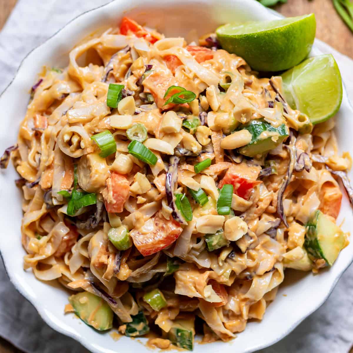 Looking down at a serving dish of peanut rice noodle salad on a table.