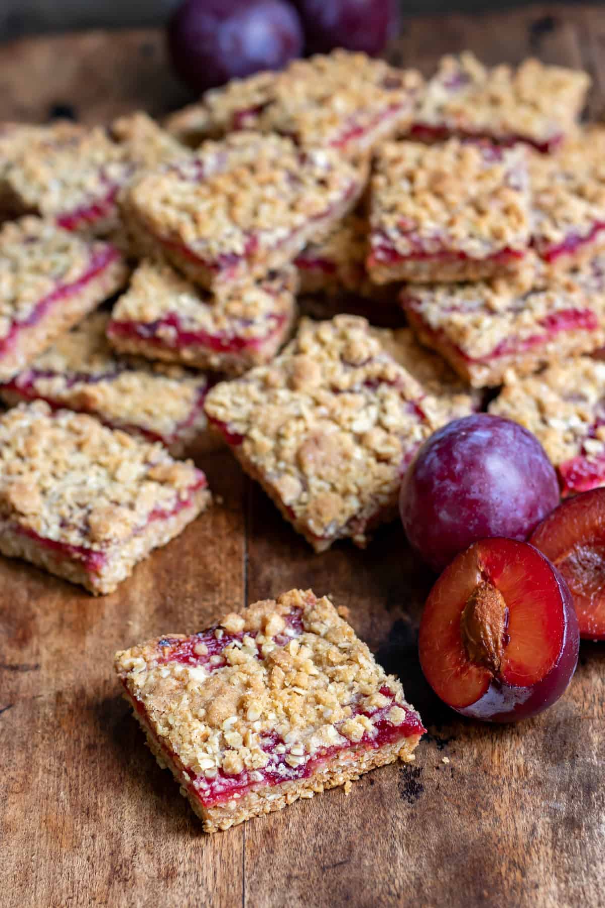 A wooden table with a plum bar in front of more plum bars.