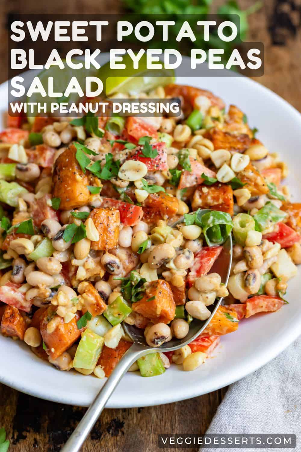 Spoon in a serving dish of bean salad, with text Sweet Potato, Black Eyed Peas Salad with Peanut Dressing.