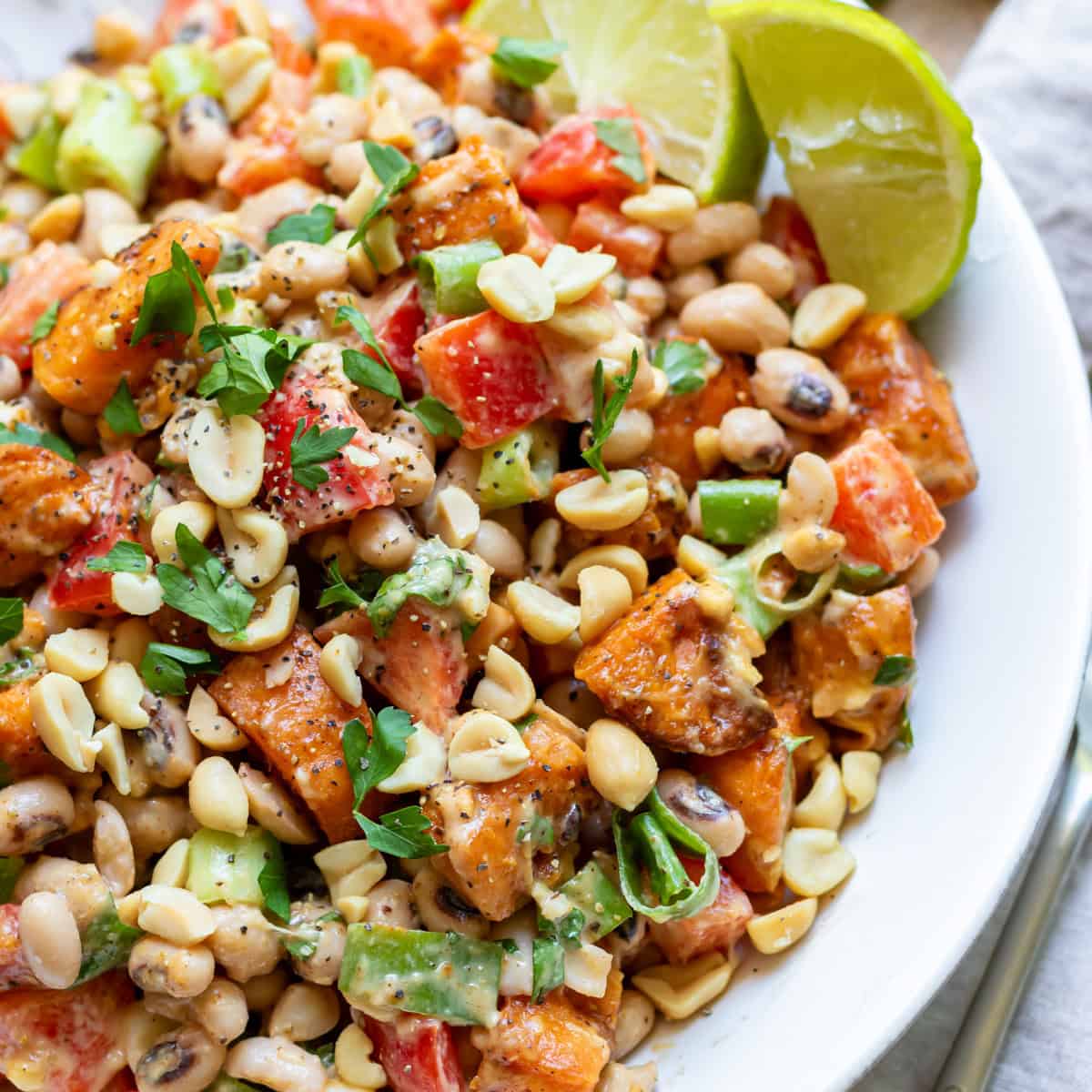 Close up of a roasted sweet potato black eyed peas salad with peanut dressing.