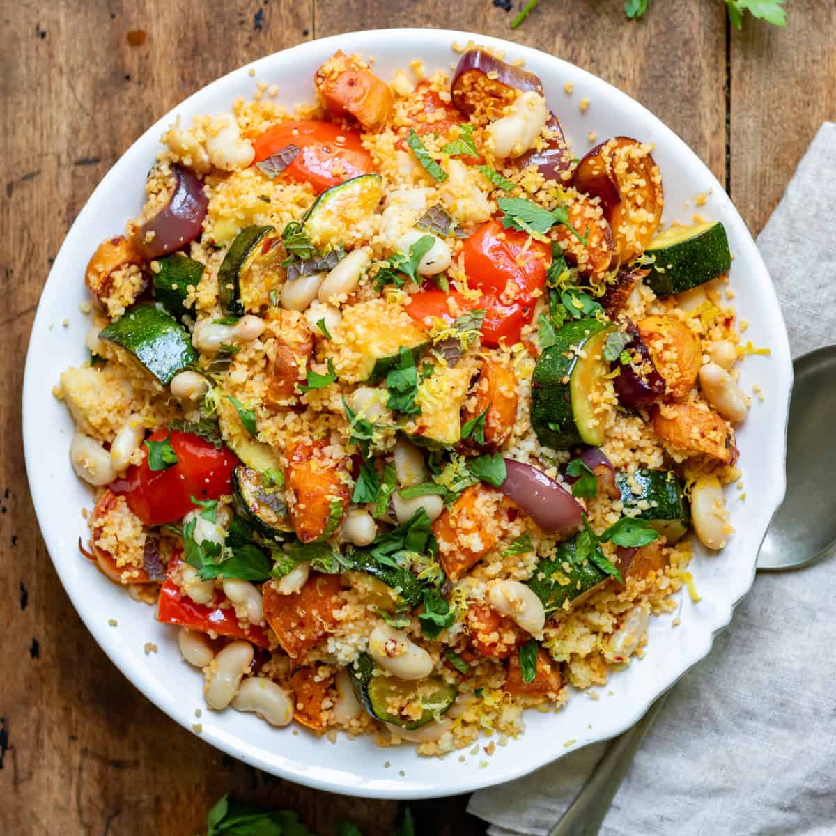 Looking down at a serving dish of roasted vegetable and bean couscous.